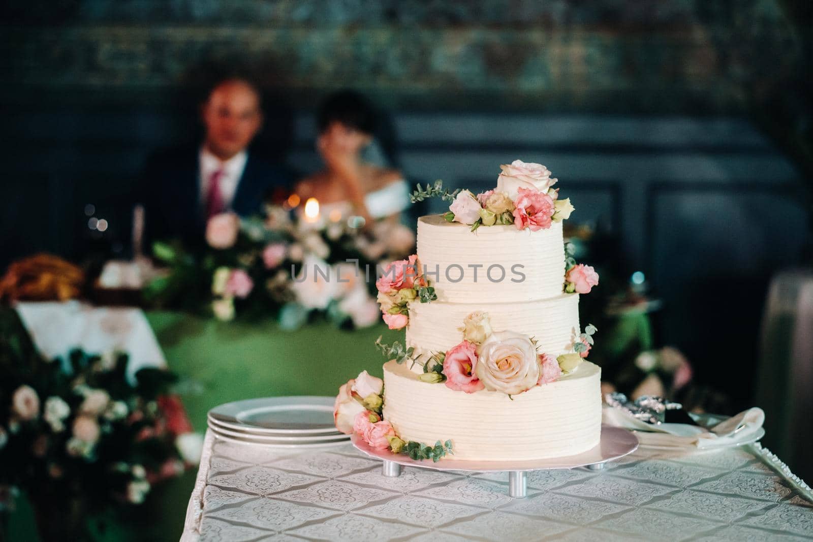 Elegant wedding cake at the wedding in three tiers.