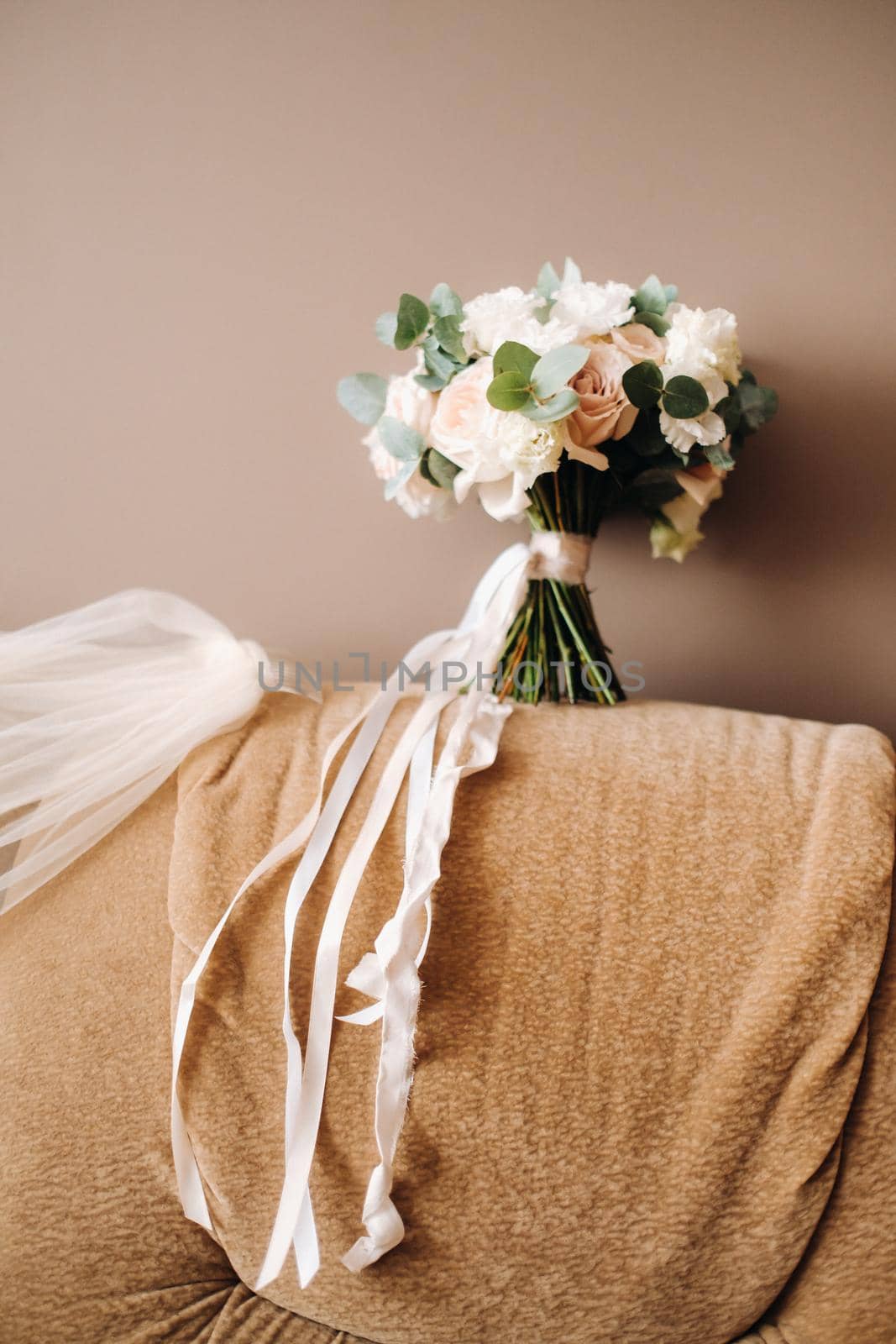 wedding bouquet with roses on a chair and boutonniere.The decor at the wedding by Lobachad