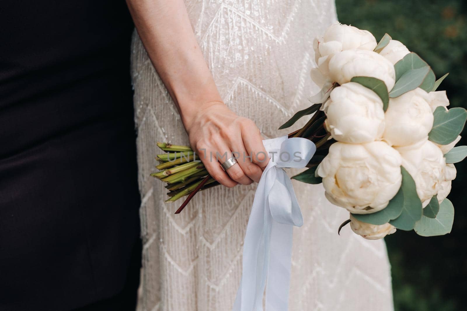 wedding bouquet with peonies in the hands of the bride at the wedding.