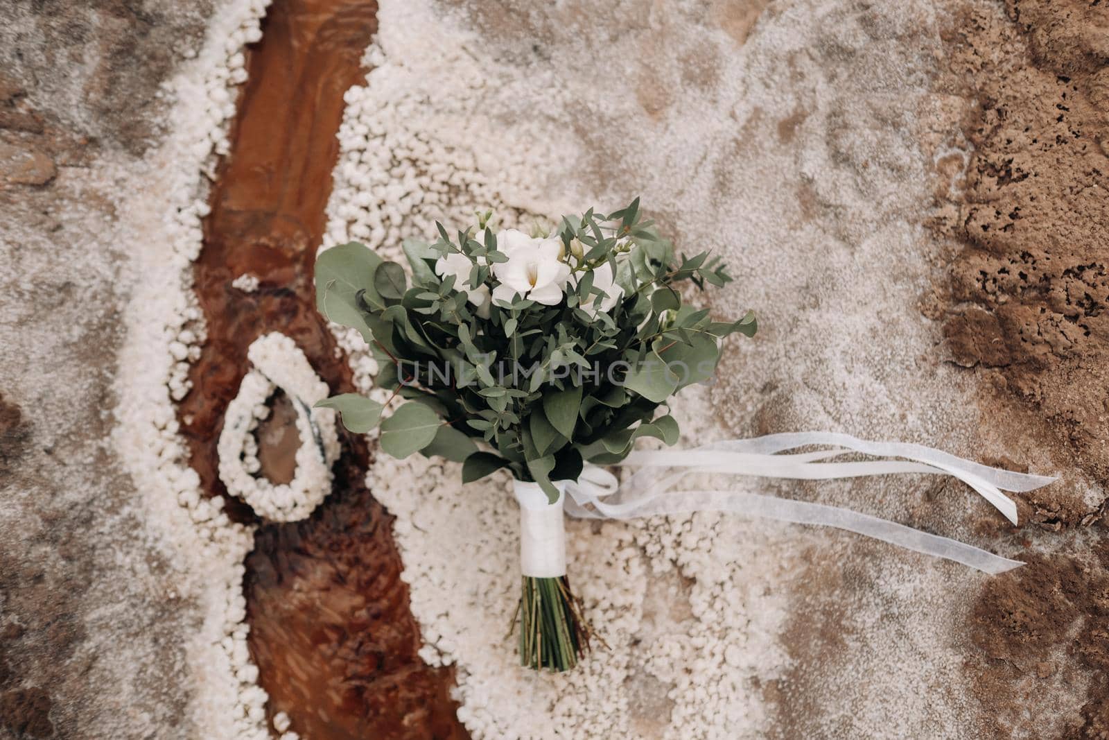 the wedding bouquet rests on a salty texture.The decor at the wedding.