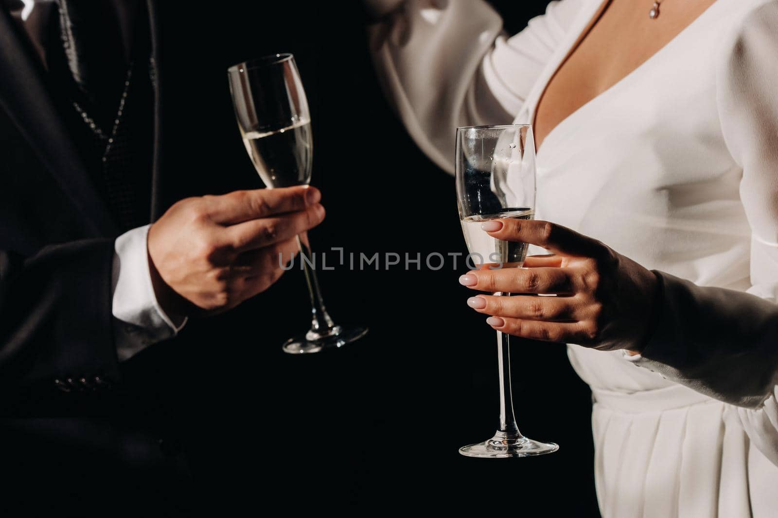 A man and a woman hold champagne glasses in their hands close-up.