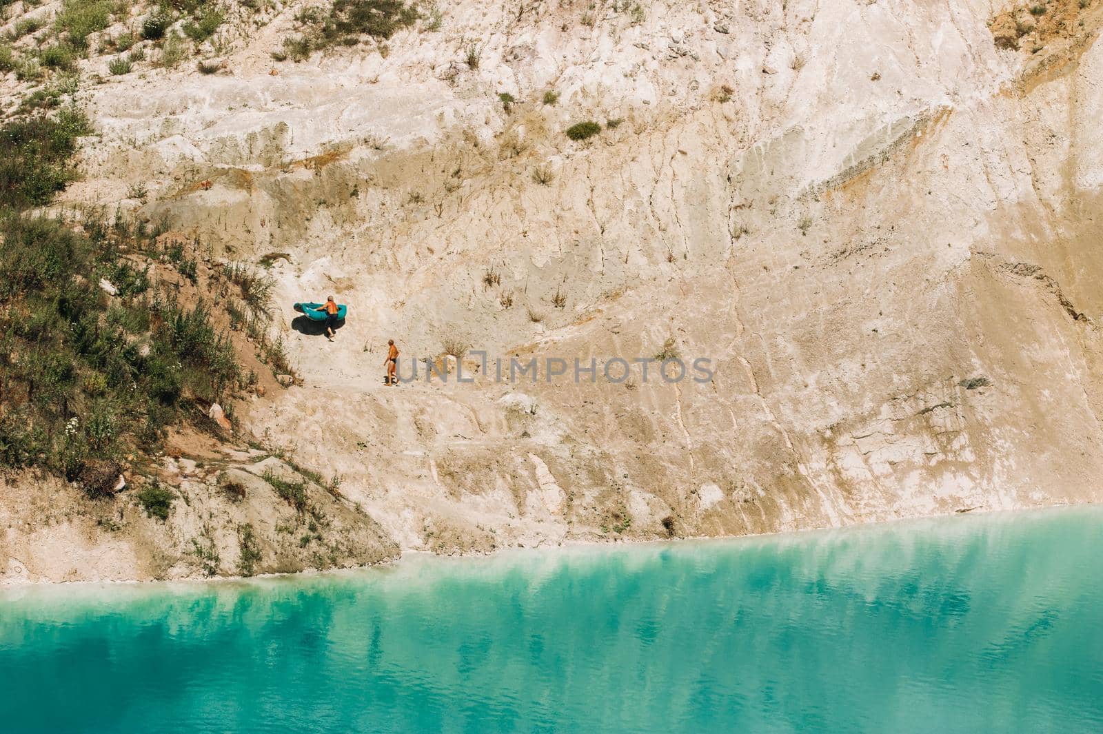 Vaukavysk chalk pits or Belarusian Maldives are beautiful saturated blue lakes.Two tourists pull a boat out of the water Belarus. by Lobachad