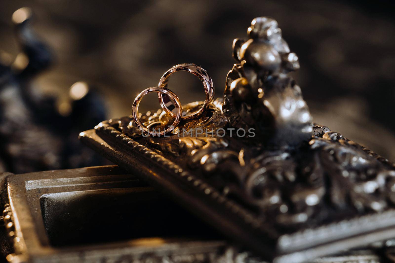 Gold wedding rings lie on an antique jewelry box. Wedding rings for ceremonies.