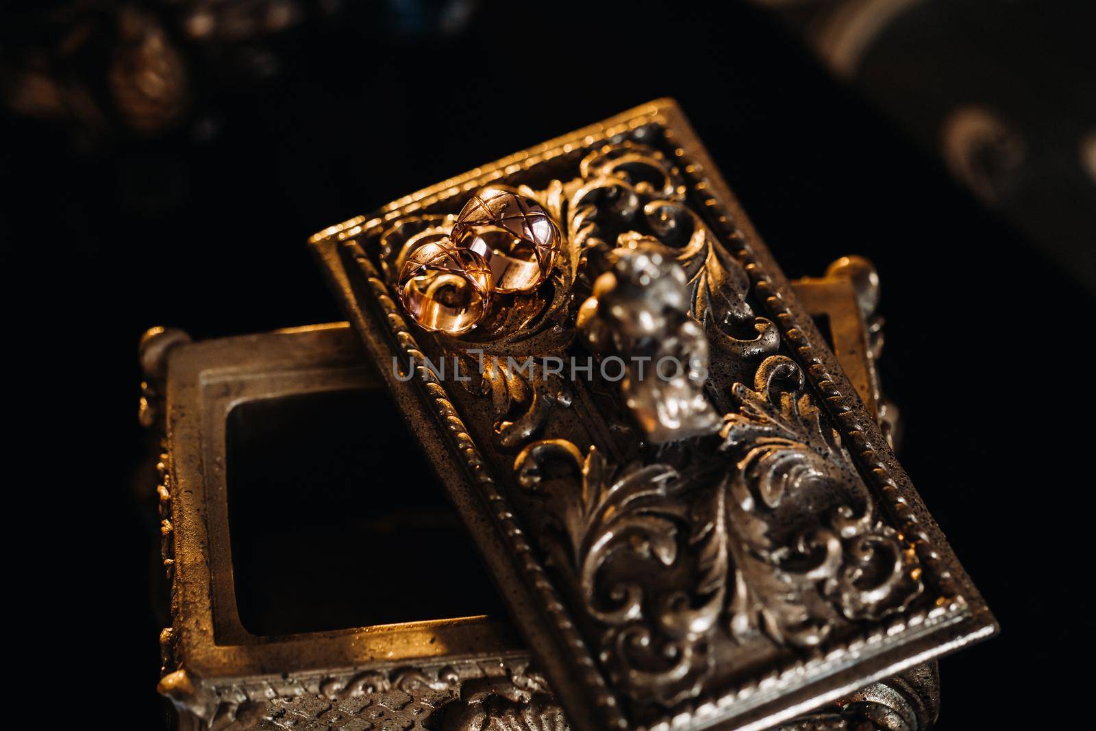 Gold wedding rings lie on an antique jewelry box. Wedding rings for ceremonies.