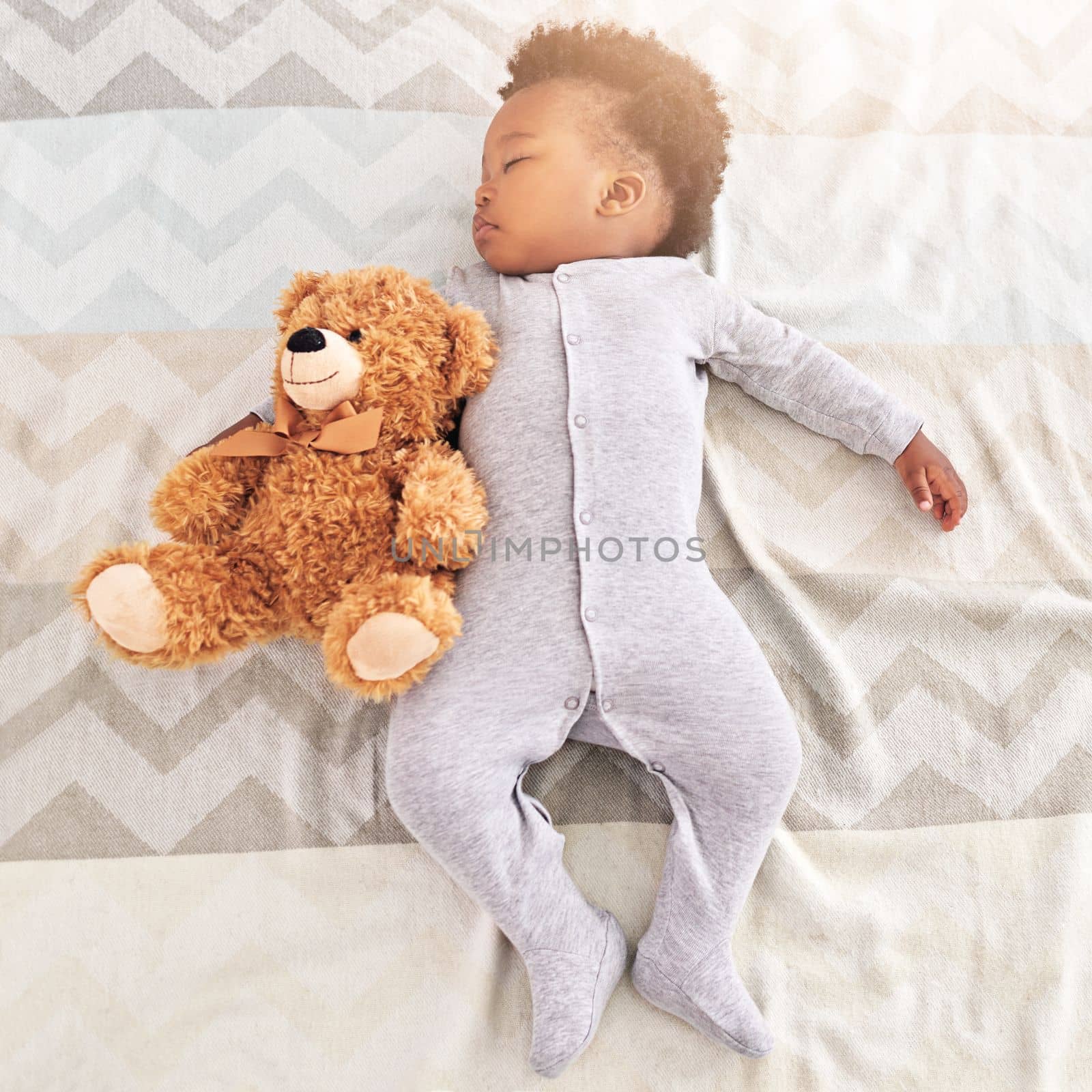 Sound asleep in a peaceful slumber. High angle shot of a little baby boy sleeping on a bed with a teddy bear
