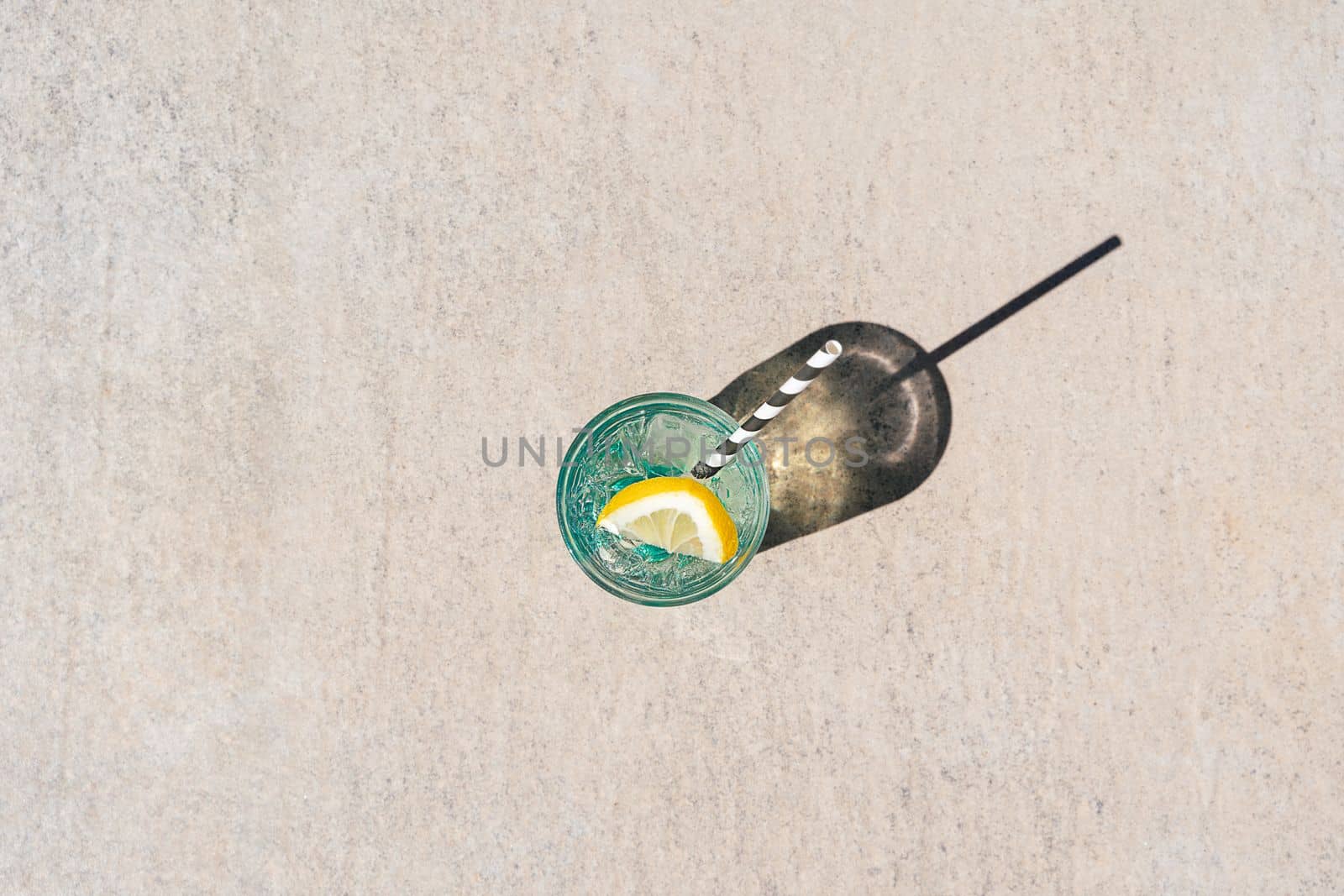 Closeup shot of tropical sparkling mint lemonade cocktail. Blank copy space picture of summer alcohol free drink dropping a shadow on marble floor. Hello summer holiday vacation