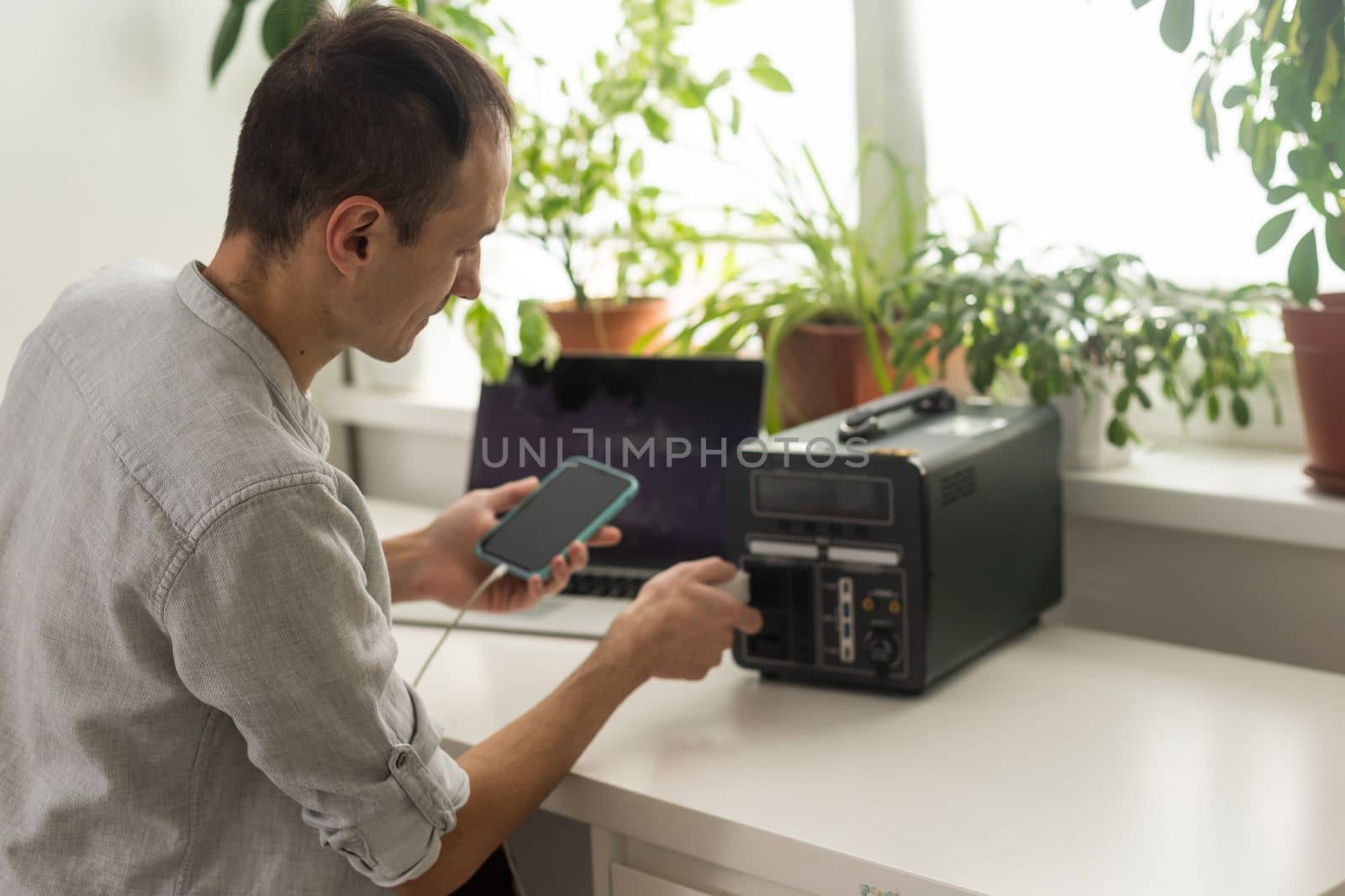 a man uses a portable charging station by Andelov13