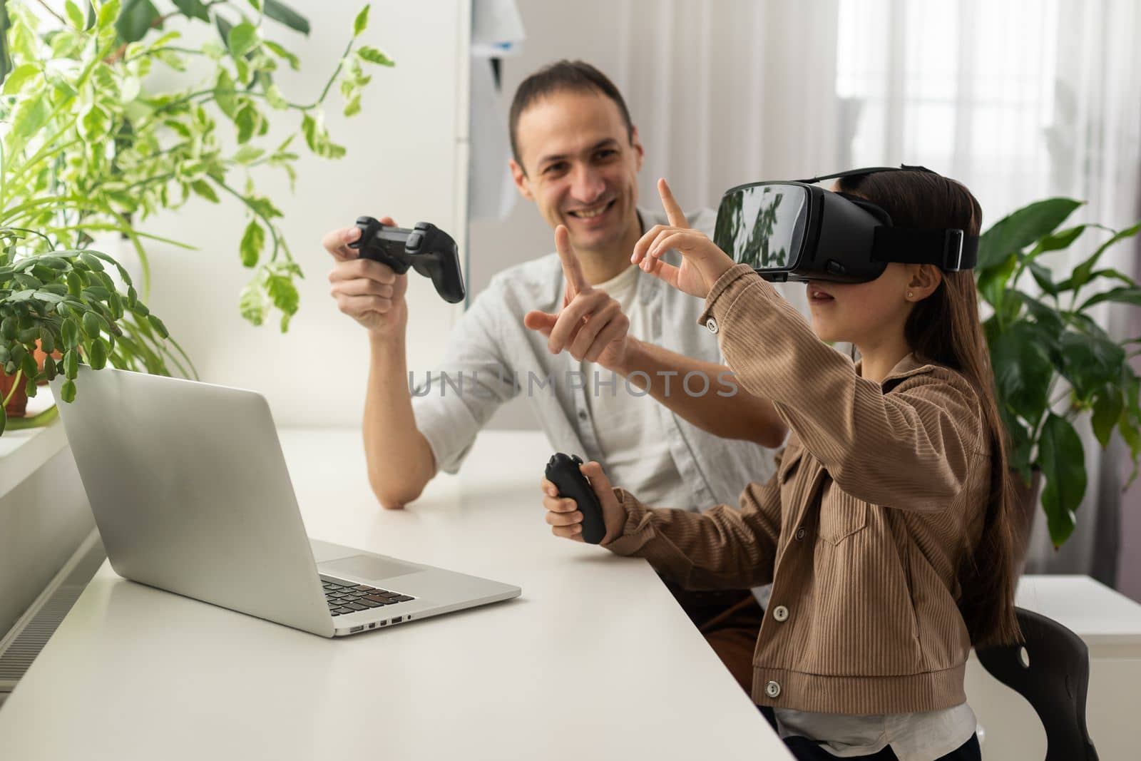 Little girl having fun time with her father using VR glasses at home for learning molecular structure. Homeschooling concept. by Andelov13