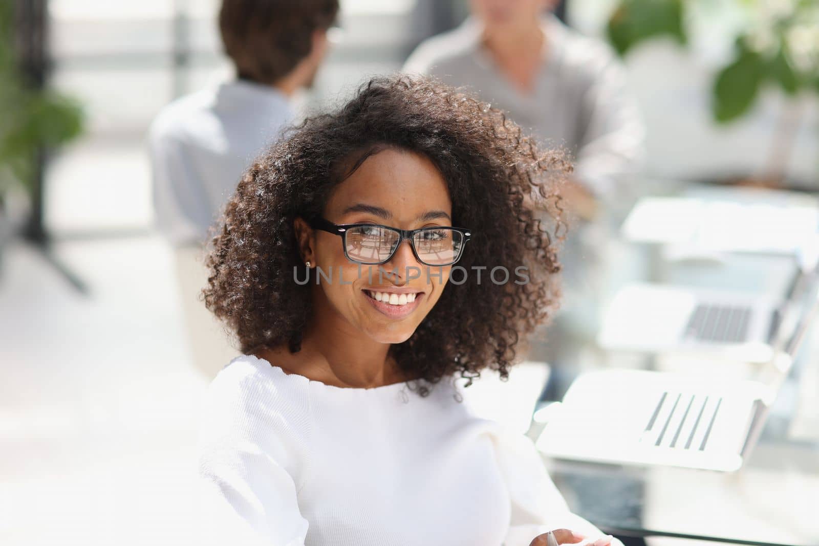 young attractive african american woman in the office sitting at the table