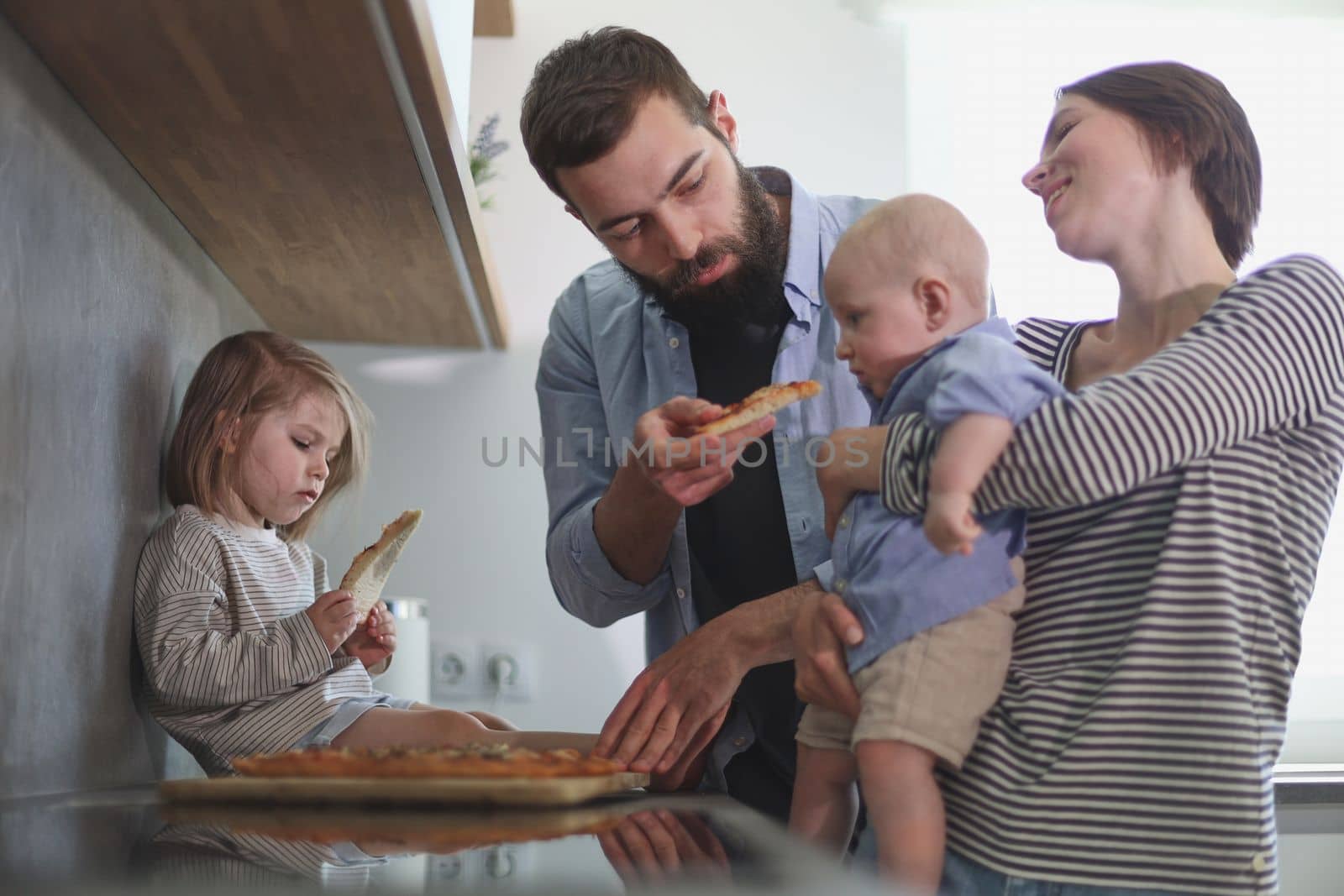 Young family with daughter and son in the kitchen