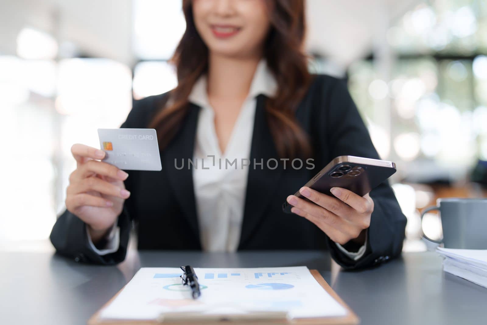 Woman makes a purchase on the smart phone with credit card, online payment, shopping online, e-commerce, internet banking concept by itchaznong