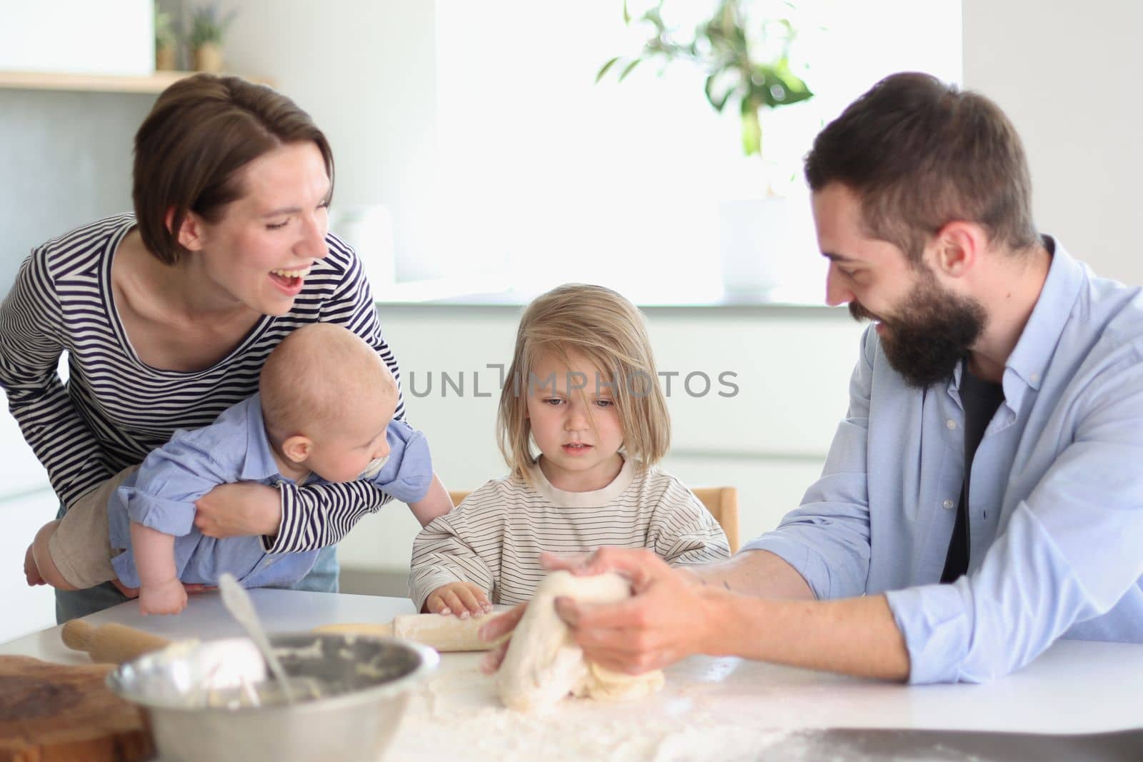 Young family with daughter and son in the kitchen