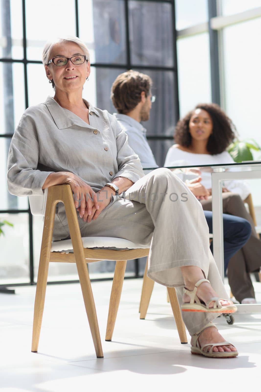 mature woman sitting with laptop looking at camera.