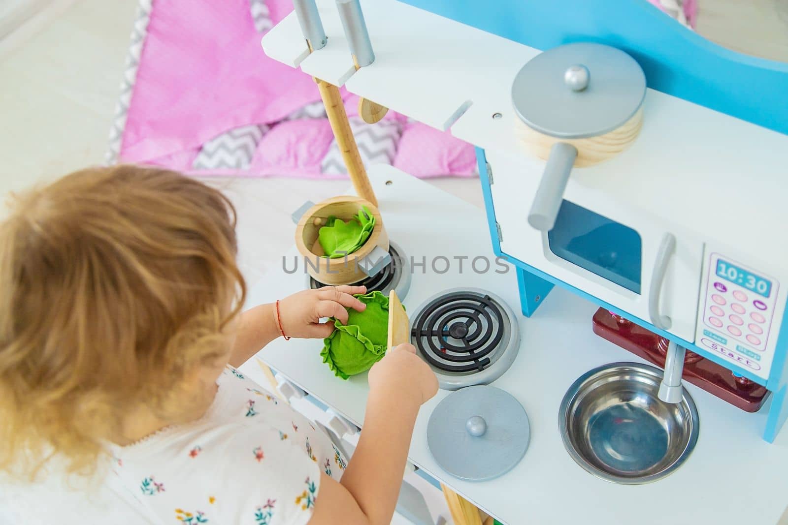 the child plays in the kitchen and cooks. Selective focus. Kid.