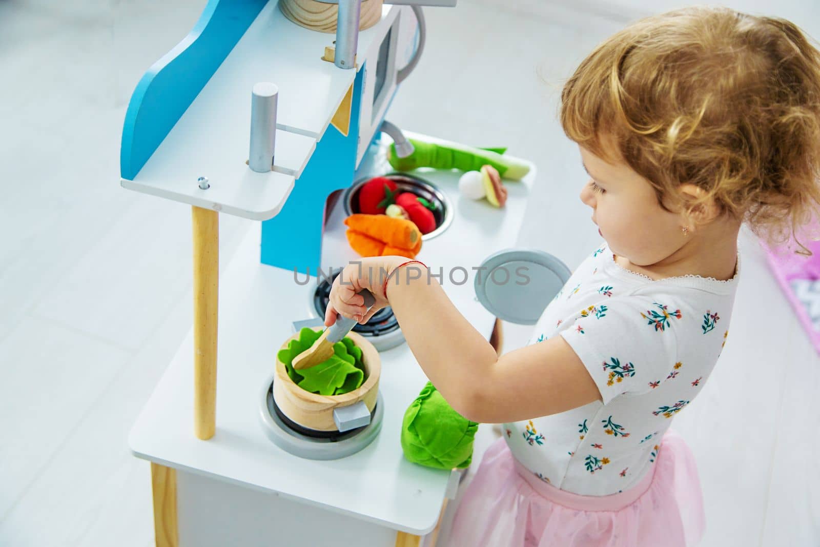 the child plays in the kitchen and cooks. Selective focus. Kid.