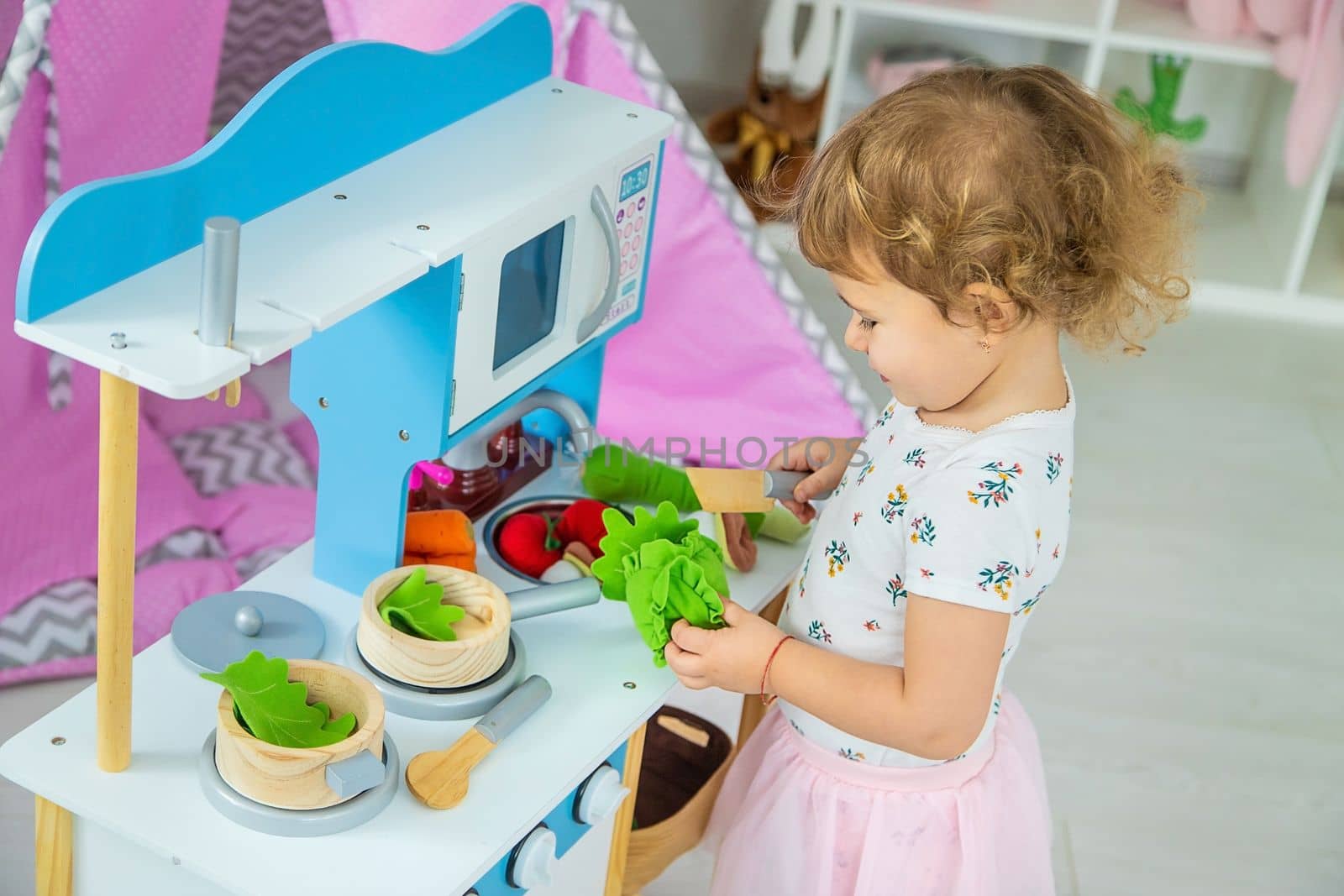 the child plays in the kitchen and cooks. Selective focus. Kid.