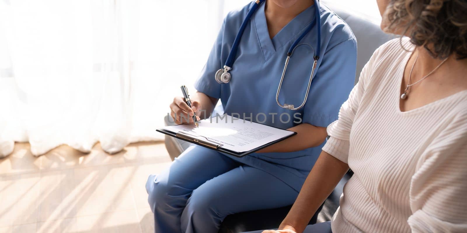 Smiling female doctor showing test results to patient in hospital. Sick senior woman having a doctor appointment. Medical consultation.