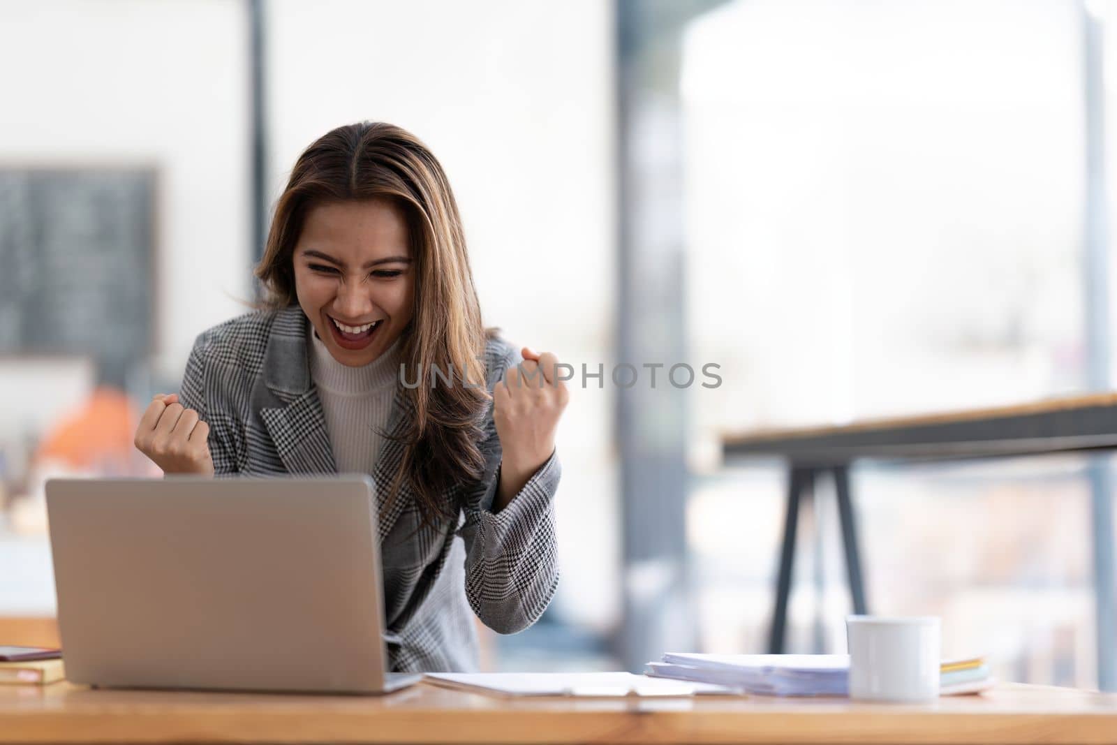 Young happy Asian businesswoman working and use laptop and thinking idea for her business.