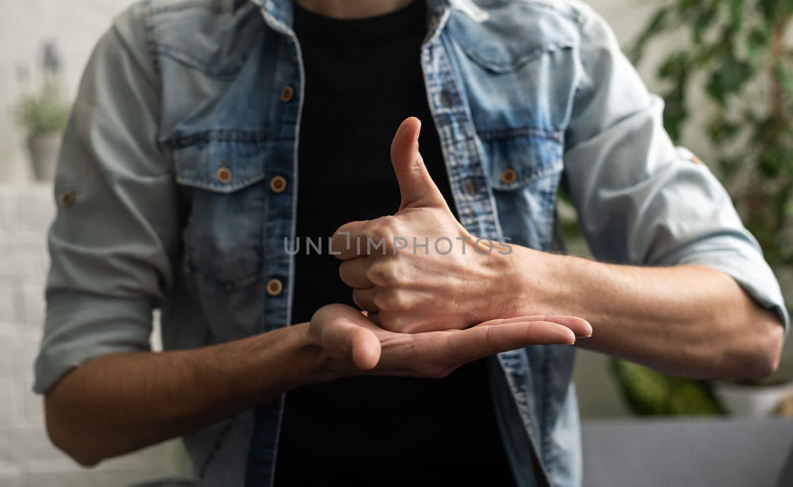 Sign language interpreter man translating a meeting to ASL, American Sign Language. Empty copy space for Editor's content by Andelov13