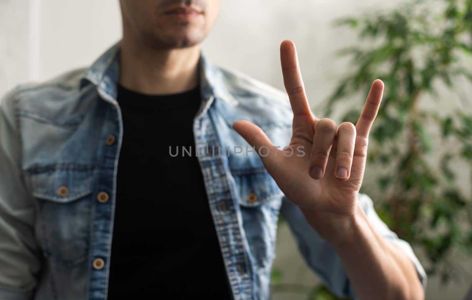 Man showing gesture in sign language on white background by Andelov13