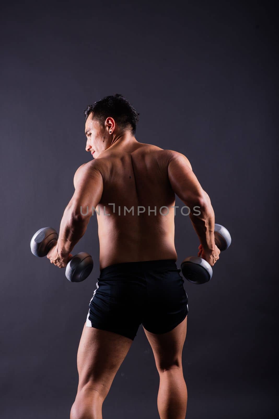 Shirtless bodybuilder showing his great body and holding dumbell. by Zelenin