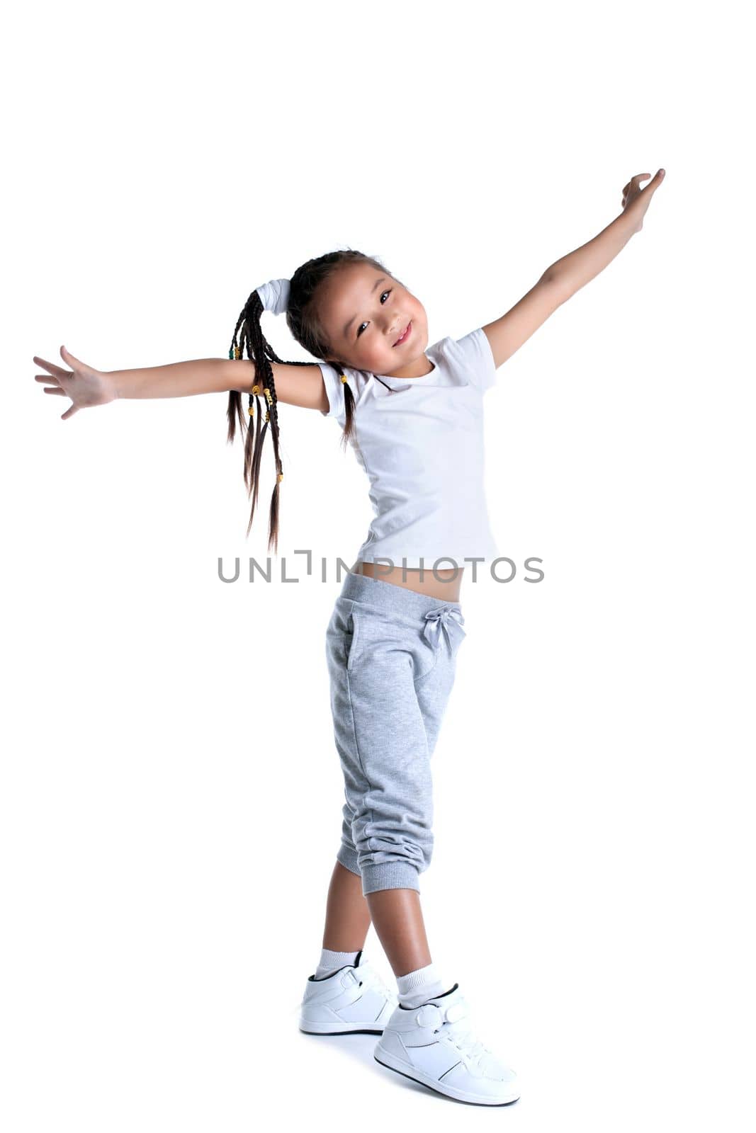Full length portrait of happy asian little girl in sportswear. Isolated on white