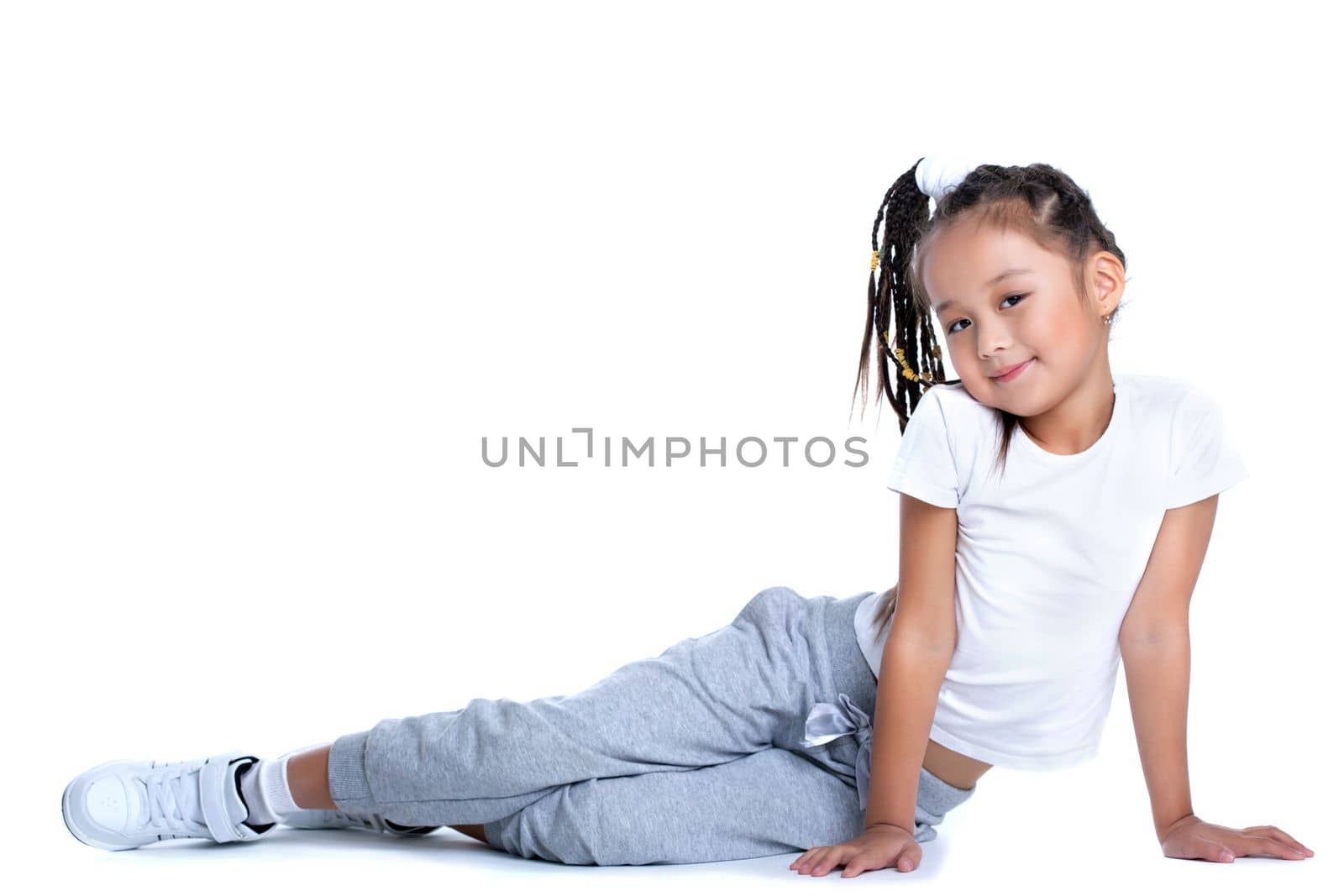 Full length portrait of asian little girl in sportswear. Isolated on white
