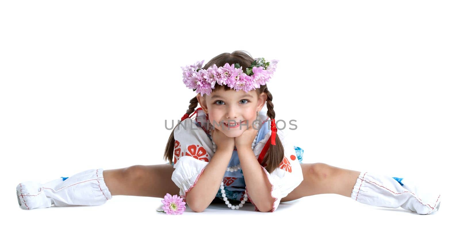 Full length portrait of little girl doing split in slavic costume and garland of flowers. Isolated on white