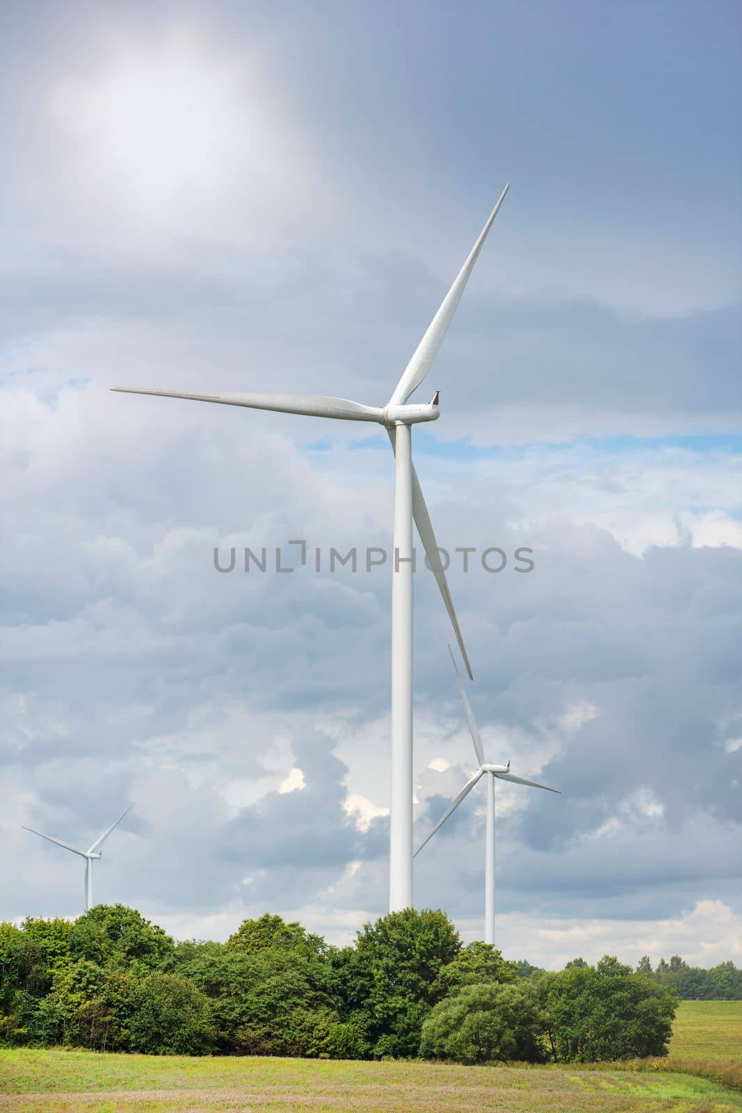 Green wind energy. Windmills for the production of renewable electricity. Windmills in the field, produce electricity on a sunny summer day by SERSOL