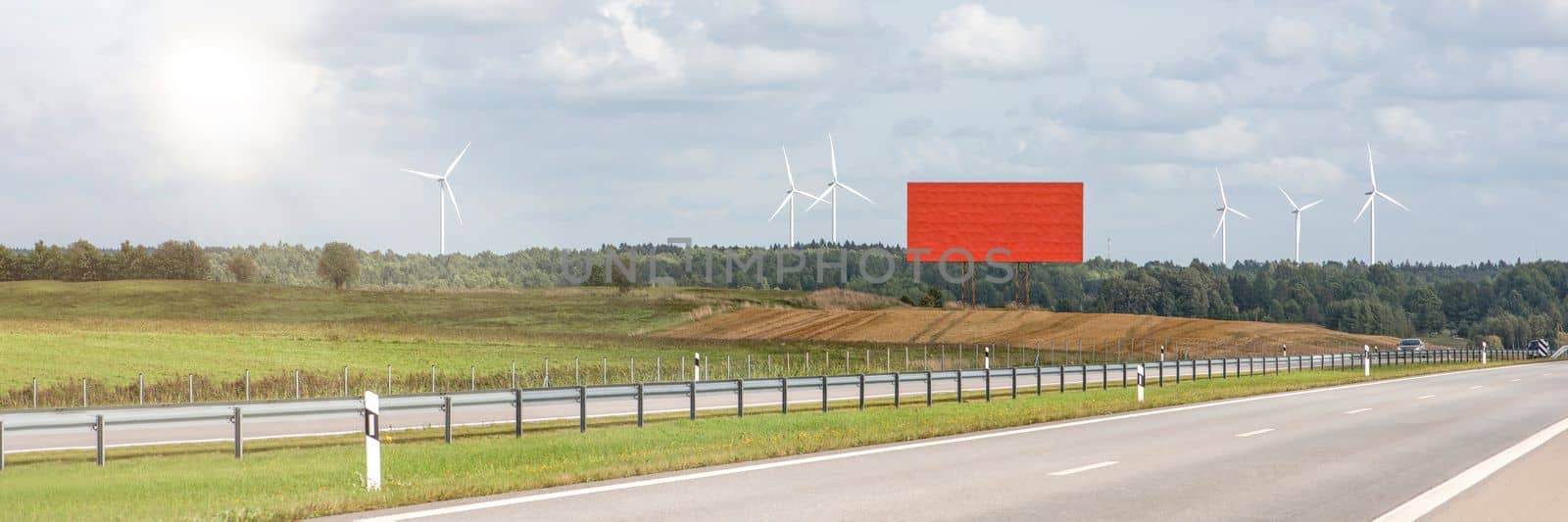 Green wind energy. Wind turbines for the production of renewable electricity. Windmills in a field produce electricity on a sunny summer day. Empty billboard to insert design, advertisement or text. by SERSOL