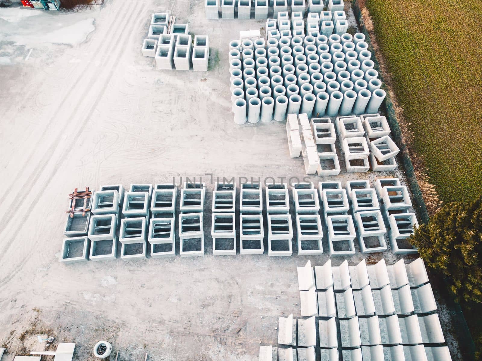Concrete pipes and boxes stacked on the grounds of a construction company by VisualProductions