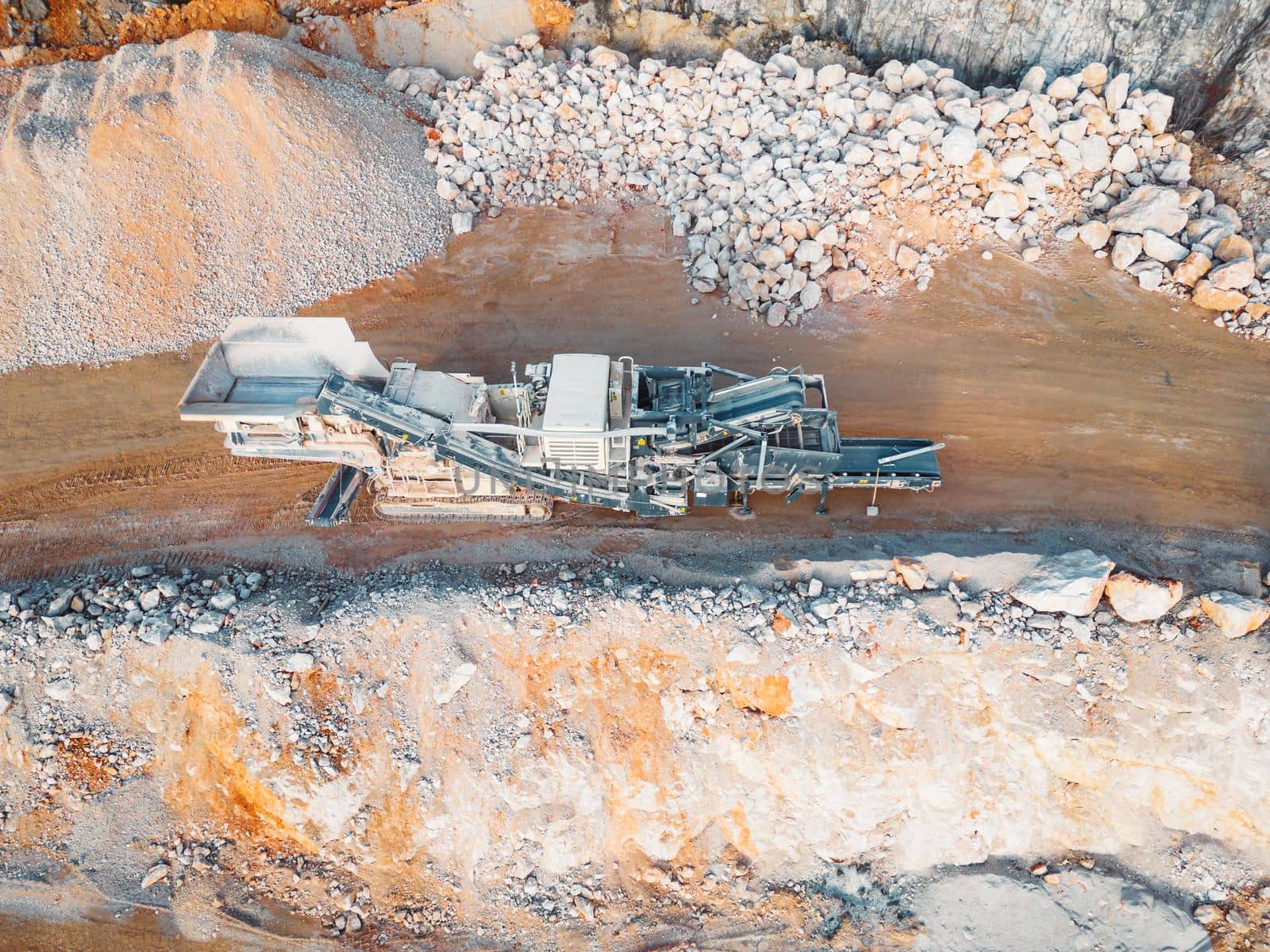 Top down view at gravel being transported on conveyor belt in the quarry by VisualProductions