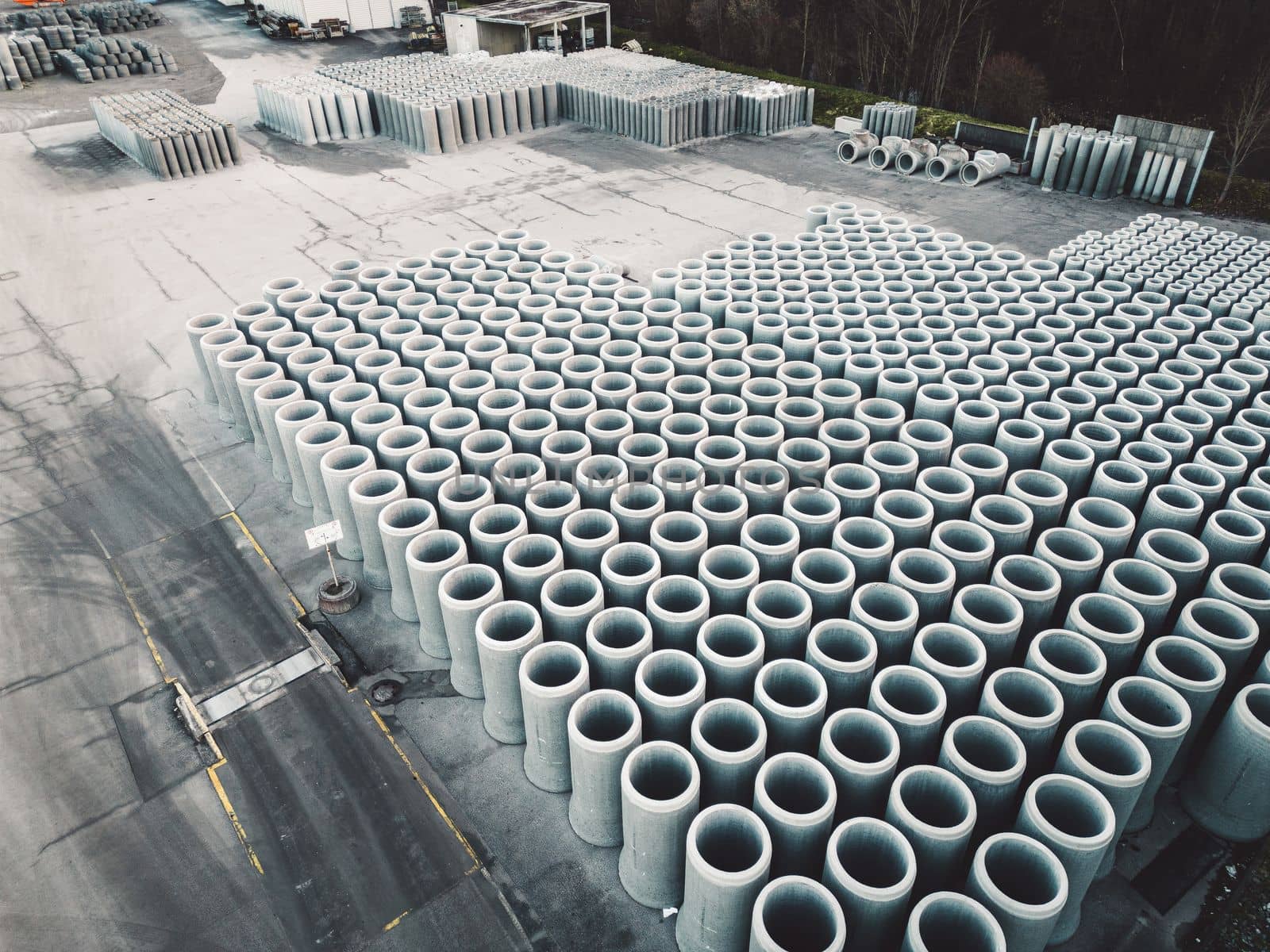 Pipe concrete manholes are stored on the ground ready for construction, for draining storm water, industrial background. High quality photo