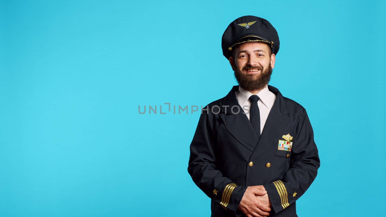 Male plane captain wearing airline uniform and posing by DCStudio