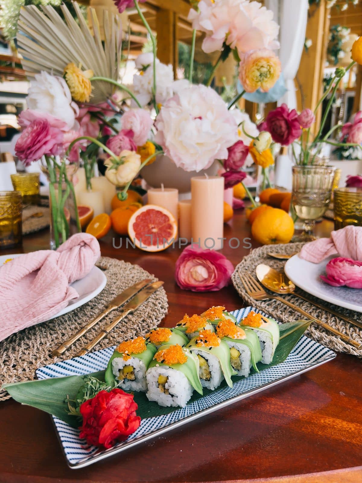 Green uramaki set lie on a rectangular dish on the table. High quality photo