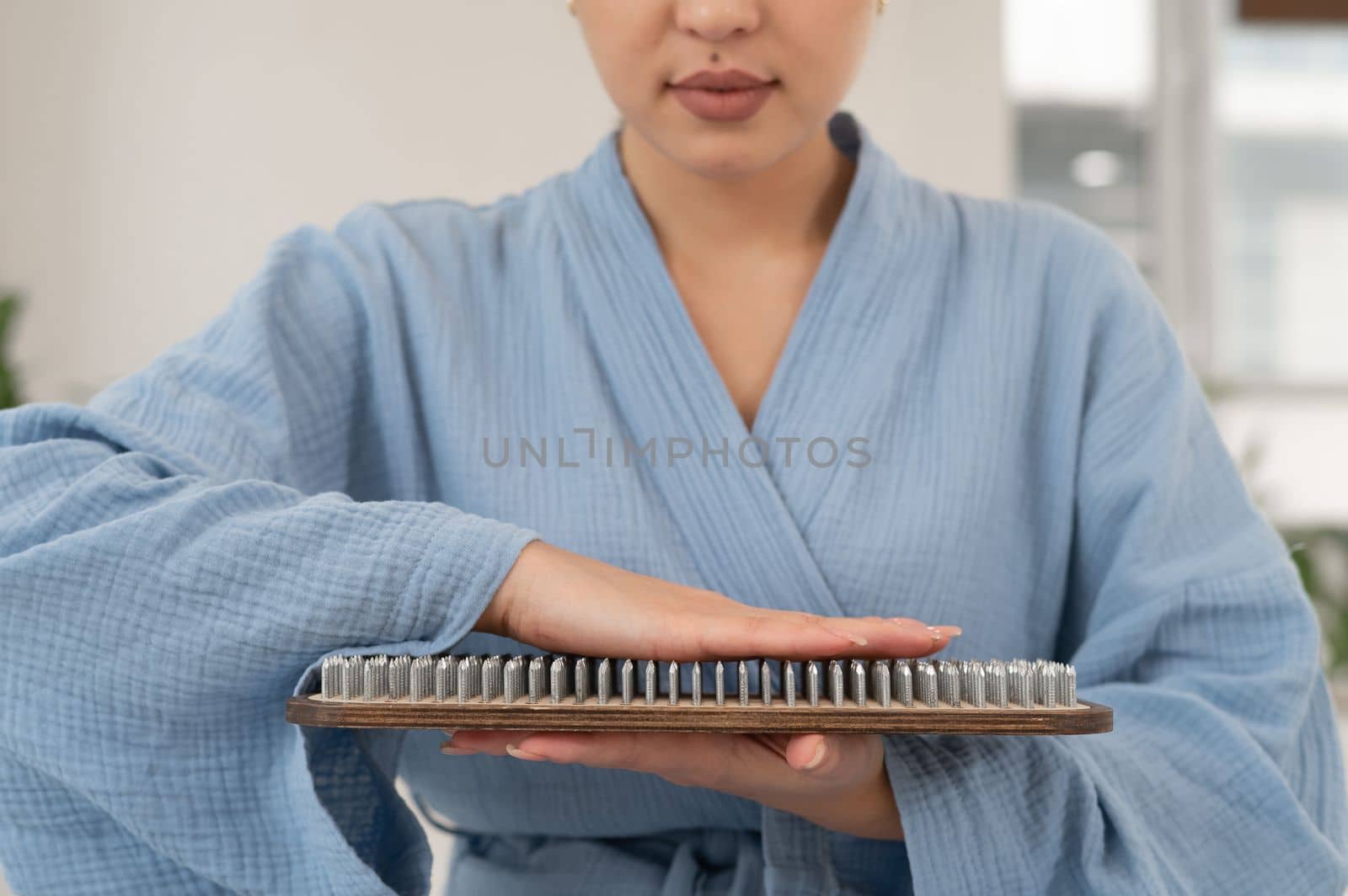 Asian woman touching Sadhu's wooden boards with nails