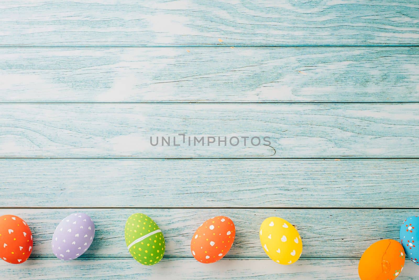 Easter Day Concept. Top view holiday banner background web design white colorful easter eggs painted on blue wood background with empty copy space, celebration greeting card, overhead, template