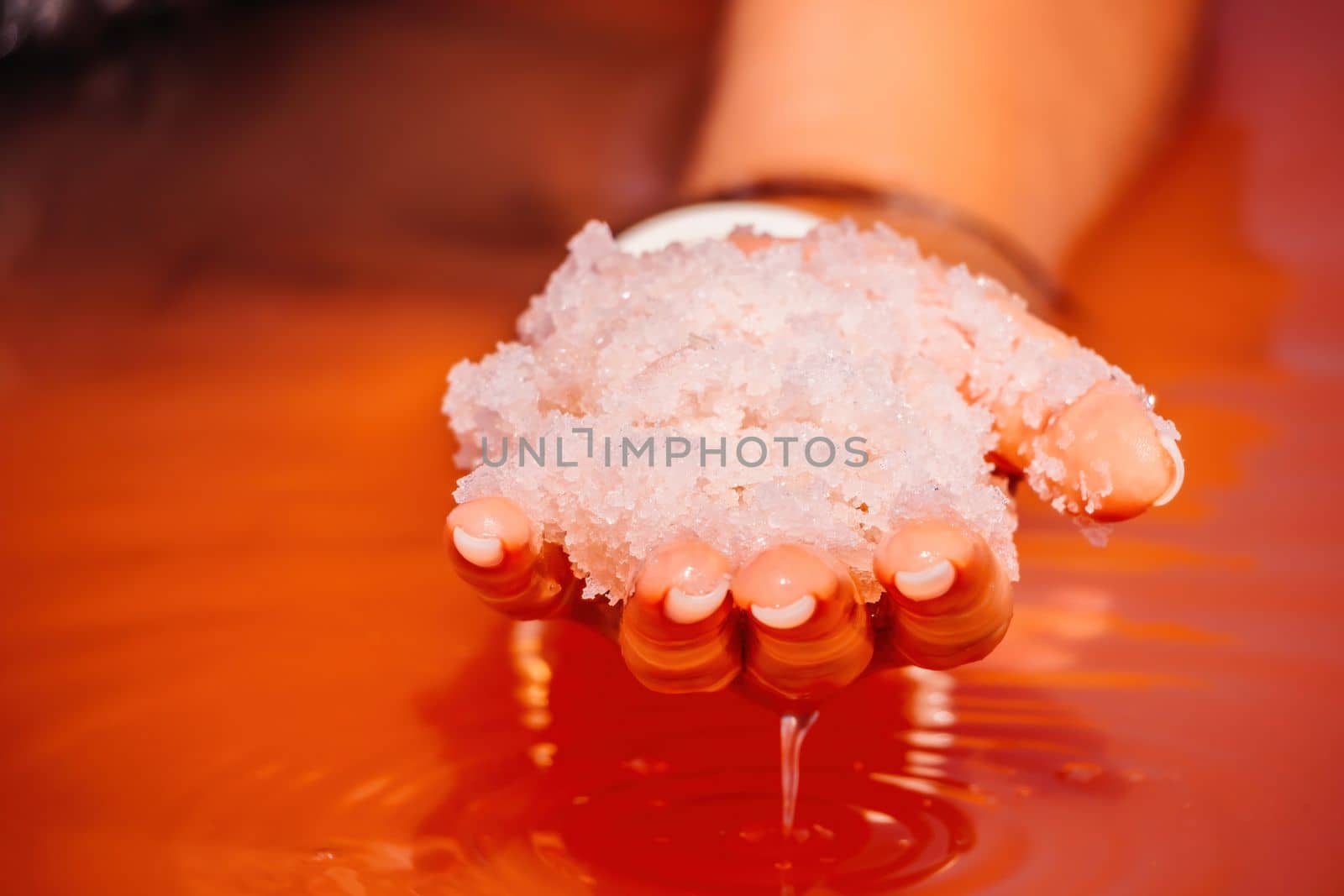 Young woman with long hair in pink salty lake with crystals of salt. Extremely salty pink lake, colored by microalgae with crystalline salt depositions. Spa, beauty and health care concept. by panophotograph