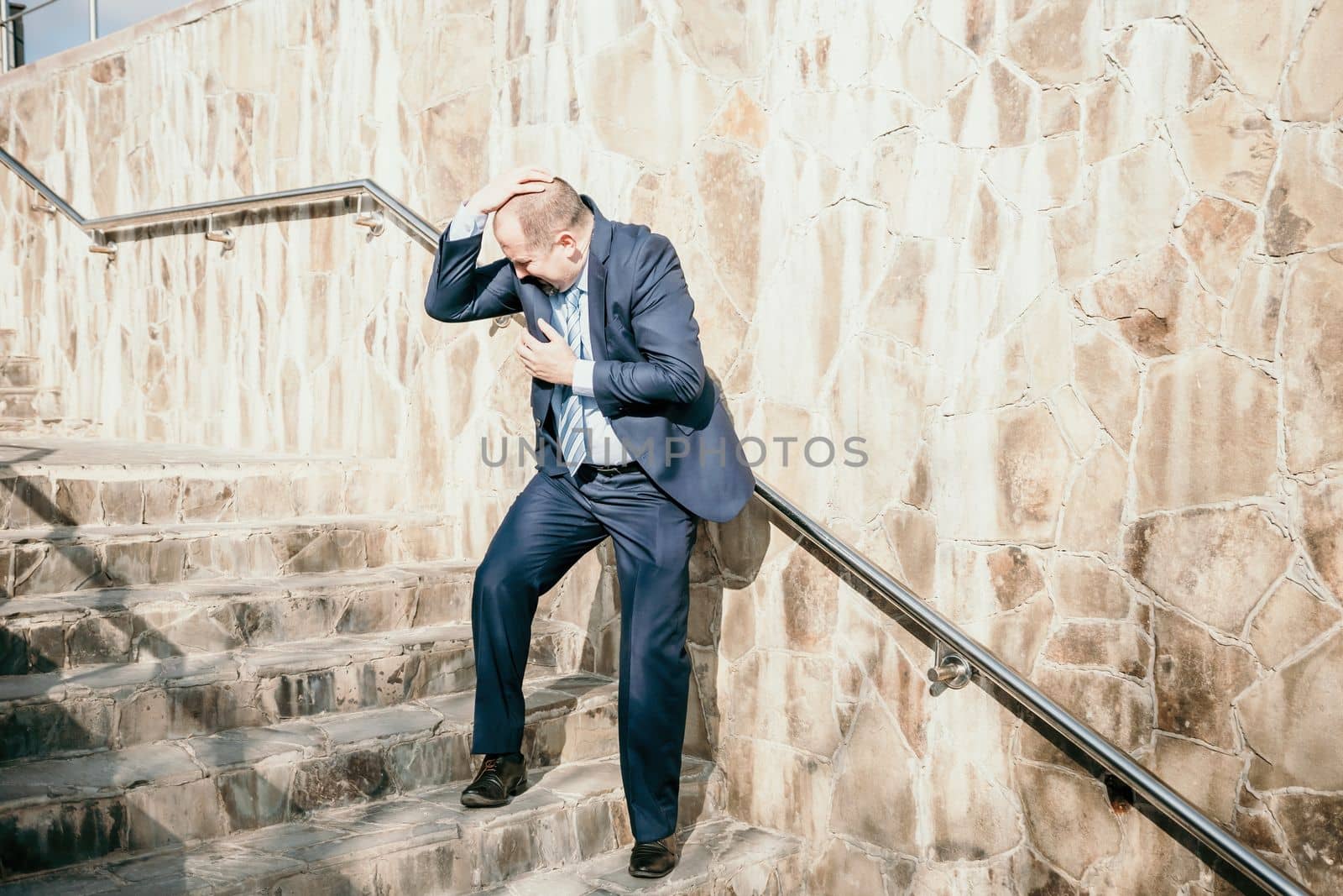 Portrait of a senior professional man in a suit with various problems. A middle-aged businessman with a briefcase descends the stairs.