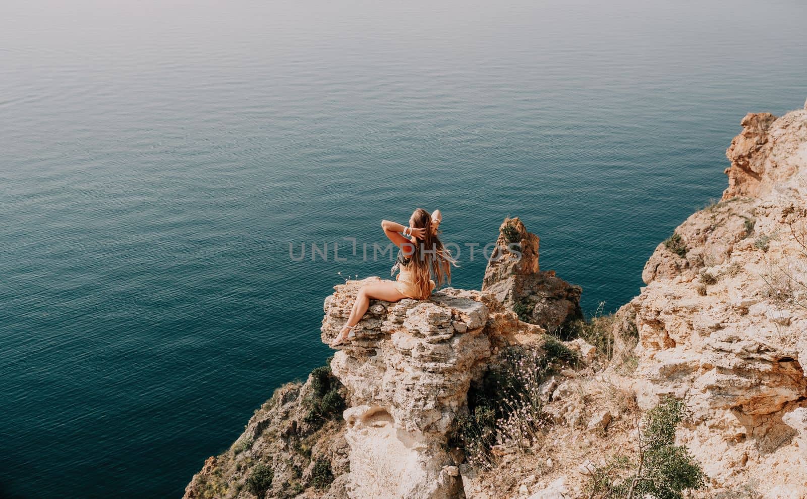 Woman travel sea. Happy tourist enjoy taking picture outdoors for memories. Woman traveler looks at the edge of the cliff on the sea bay of mountains, sharing travel adventure journey by panophotograph