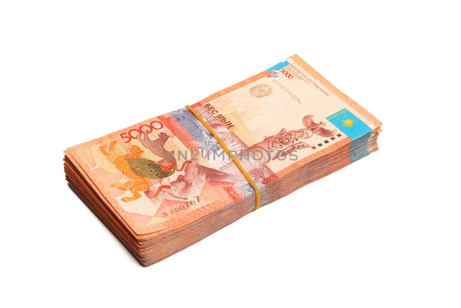 Bundle of Kazakhstan banknotes of 5000 tenge tied with an elastic band, isolated on white.