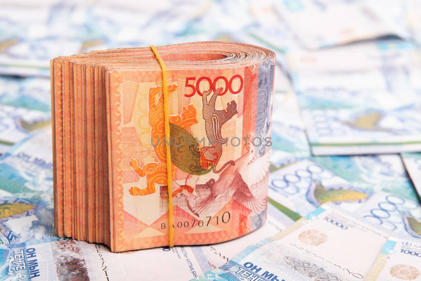 Pack of 5000 banknotes of Kazakhstan tenge, against the background of lay out Kazakhstani money.