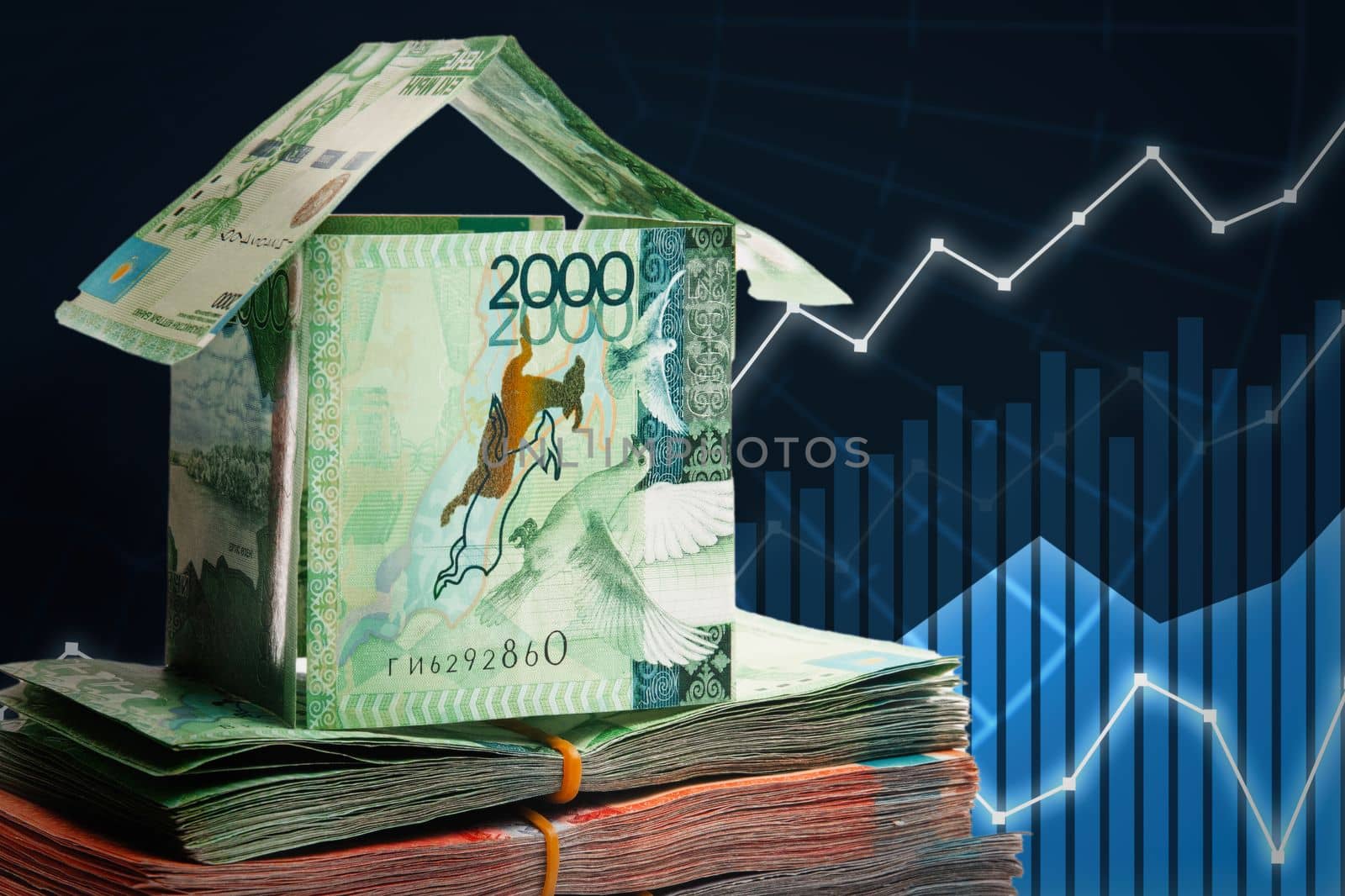 House made of banknotes of Kazakh money stands on packs of tenge. Real estate price growth concept.