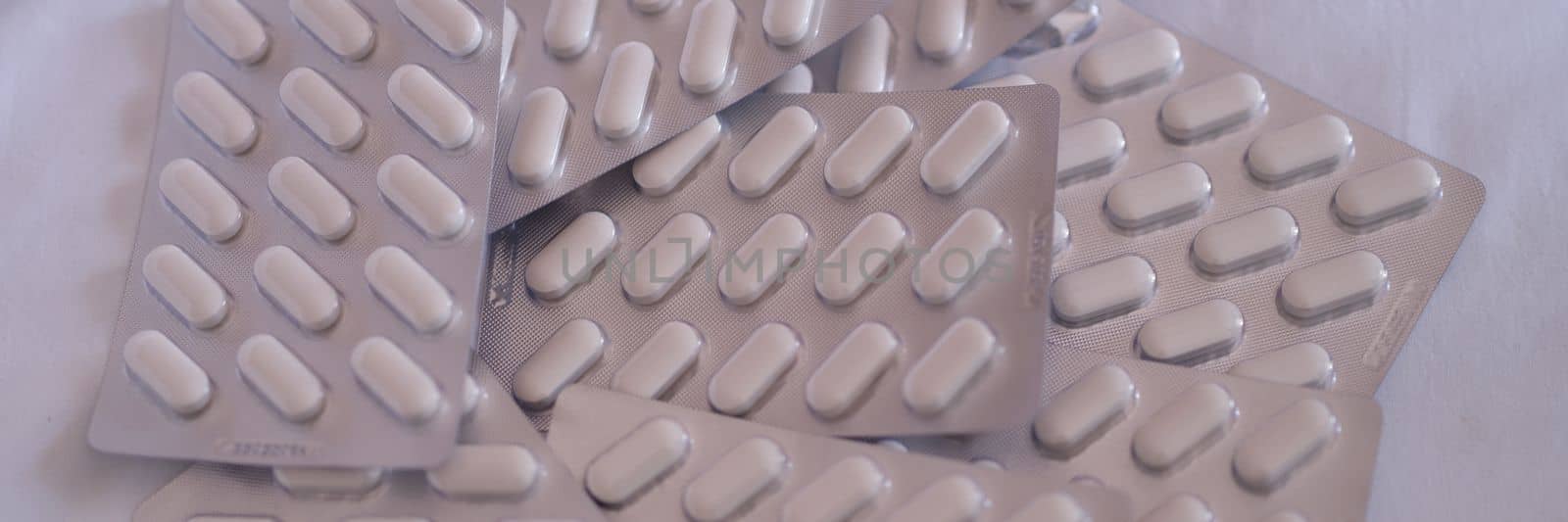 Pile of medical pills in blister pack closeup by kuprevich