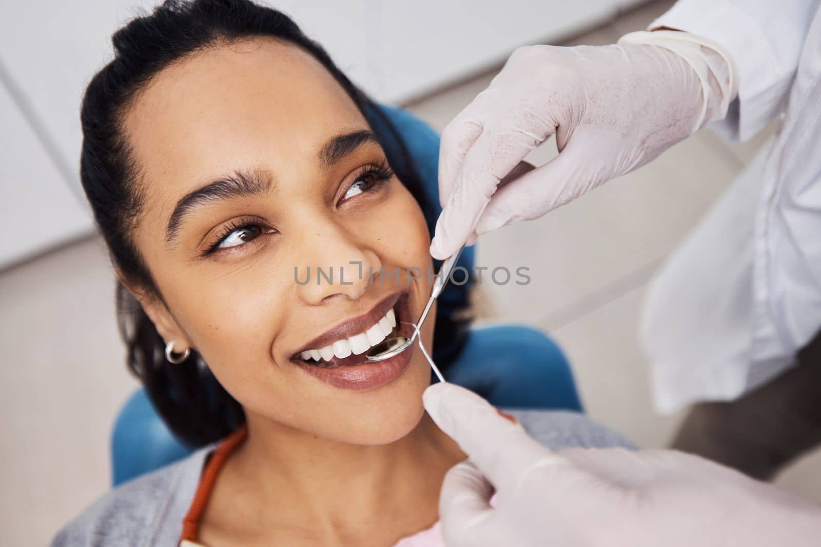 Her teeth are a dentists dream. a young woman having dental work done on her teeth. by YuriArcurs