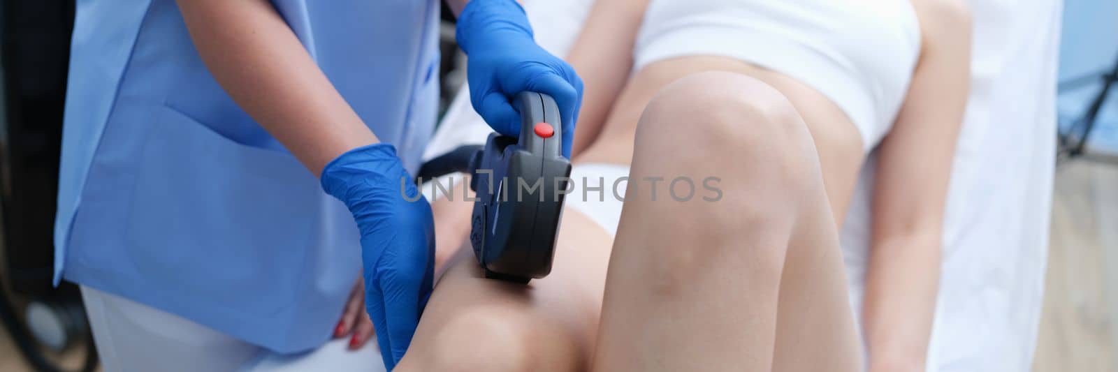 Laser hair removal on beautiful female legs in beauty clinic by kuprevich