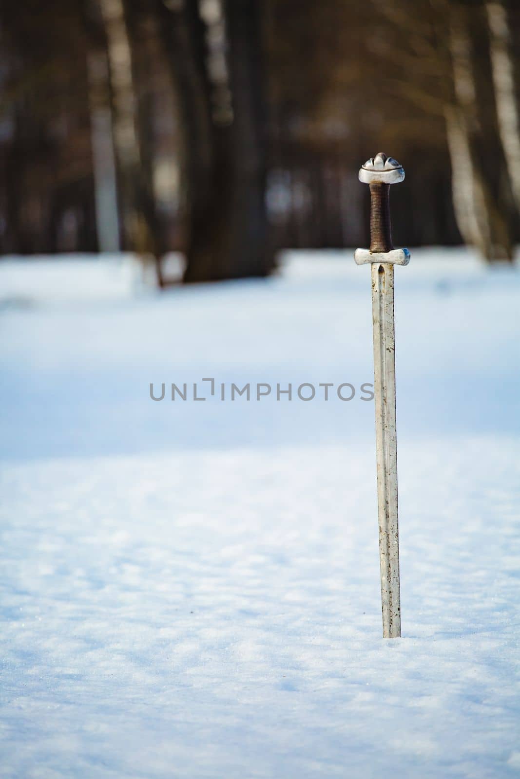 Image of silver sword fantasy medieval period at the background of winter landscape.