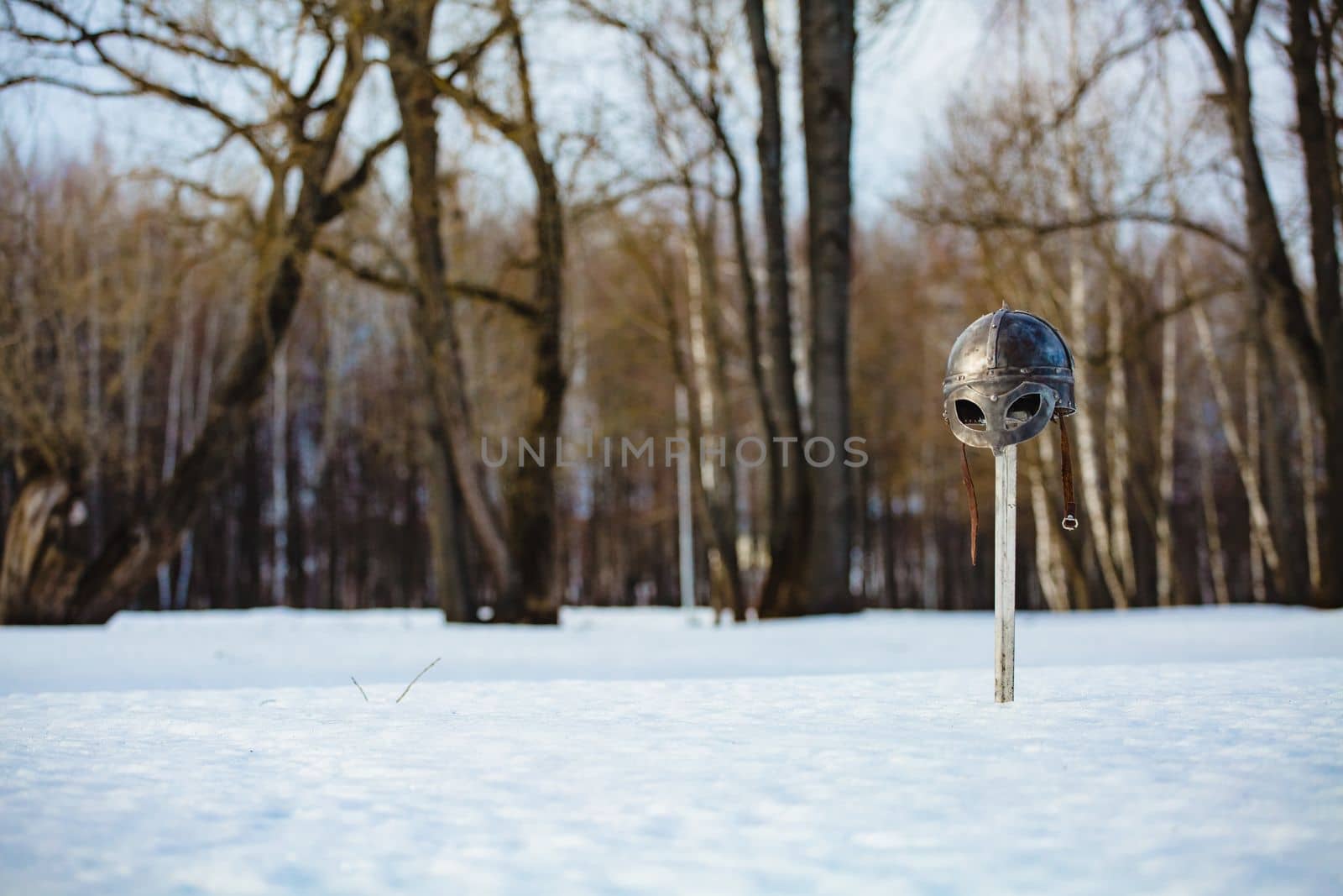 Image of silver sword and helmet fantasy medieval period at the background of winter landscape