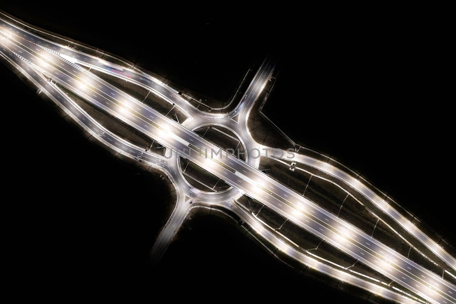 Aerial view of urban highway intersection road in the night light.