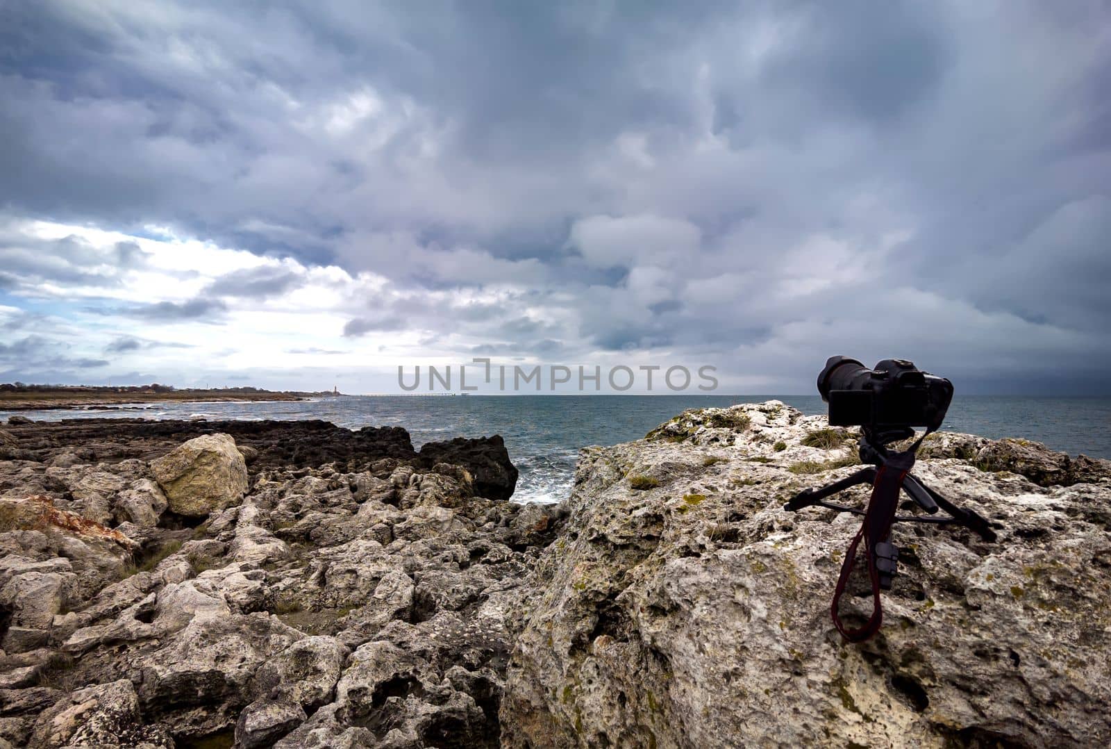 Action camera on a tripod standing on the sea coast and shooting a timelapse video